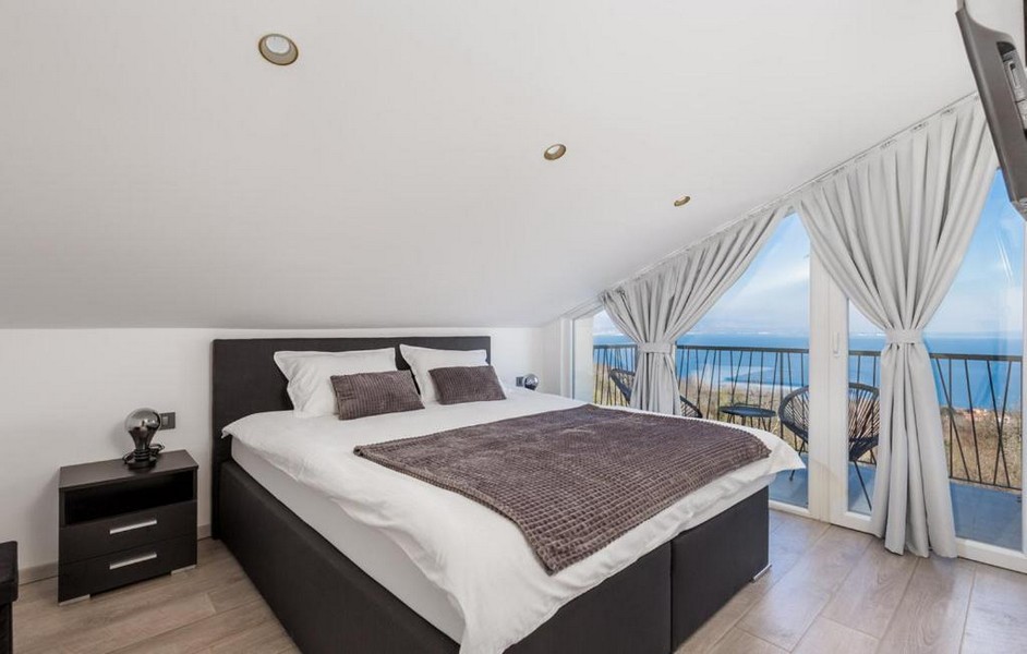 Sypialnia ze skośnym sufitem i widokiem na morze