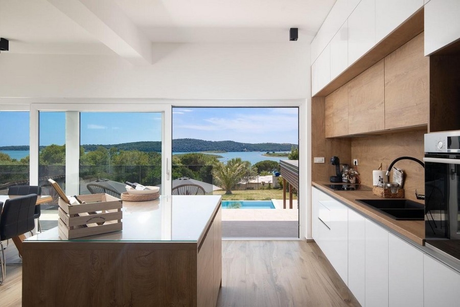 Nowoczesna kuchnia z widokiem na basen i morze.