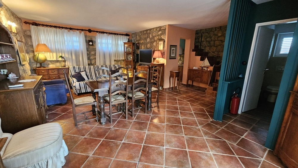 Przytulny salon z jadalnią, kamienną ścianą i drewnianymi meblami