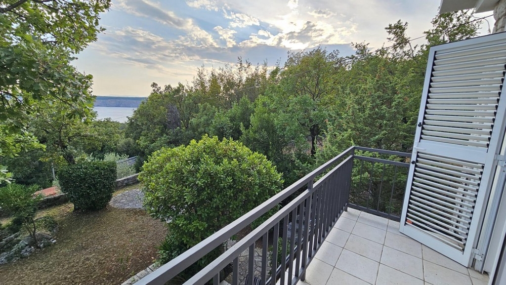 Balkon z widokiem na drzewa i morze w tle