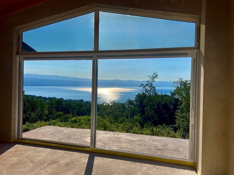 Widok na morze z poddasza przez duże szklane fronty Villi H3435 w Chorwacji.