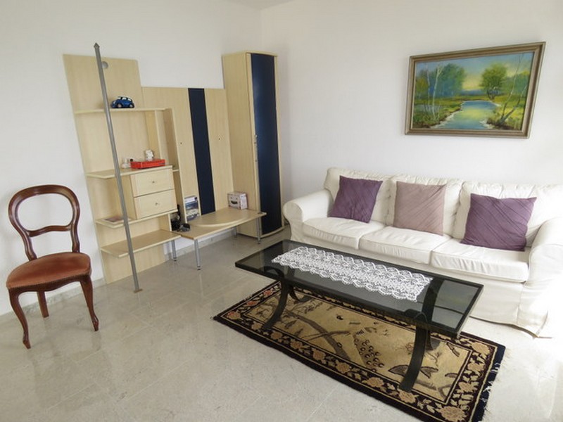 Przytulny salon z półką i dekoracyjnym dywanem.