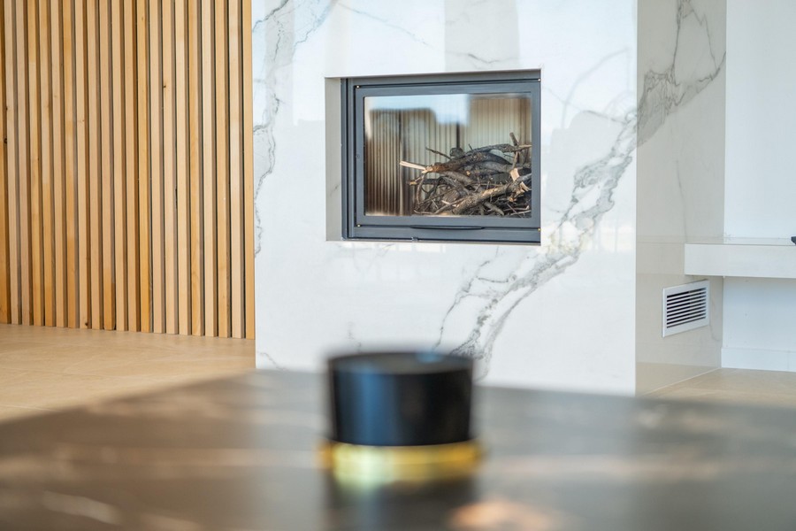 W salonie kominek z nowoczesną marmurową dekoracją