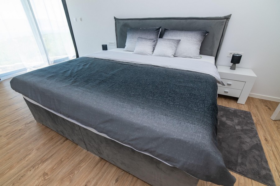 Sypialnia z szarym łóżkiem i nowoczesnym designem