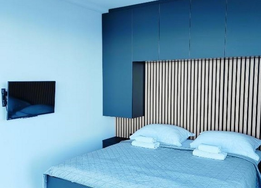 Sypialnia z nowoczesną drewnianą boazerią