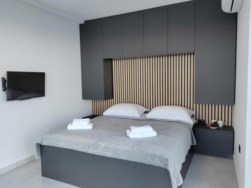 Podwójne łóżko w sypialni z drewnianymi detalami