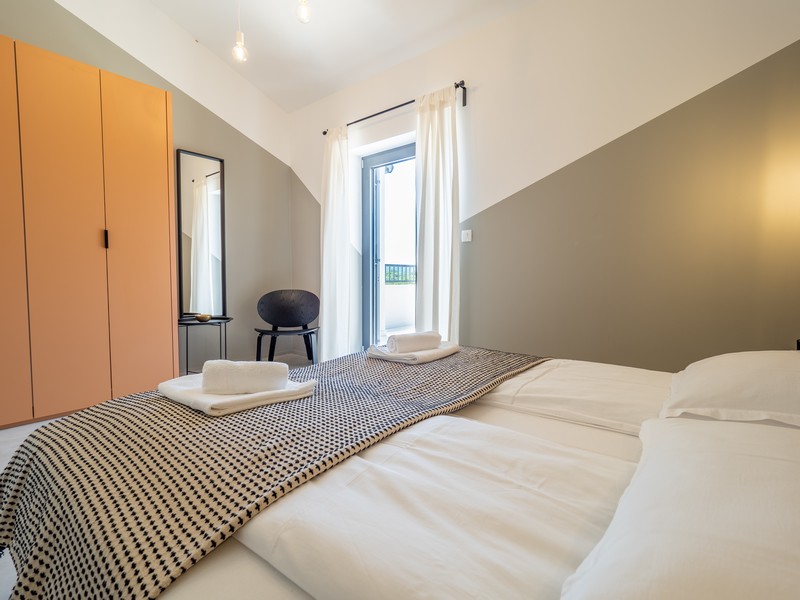 Sypialnia z łóżkiem małżeńskim i wyjściem na balkon