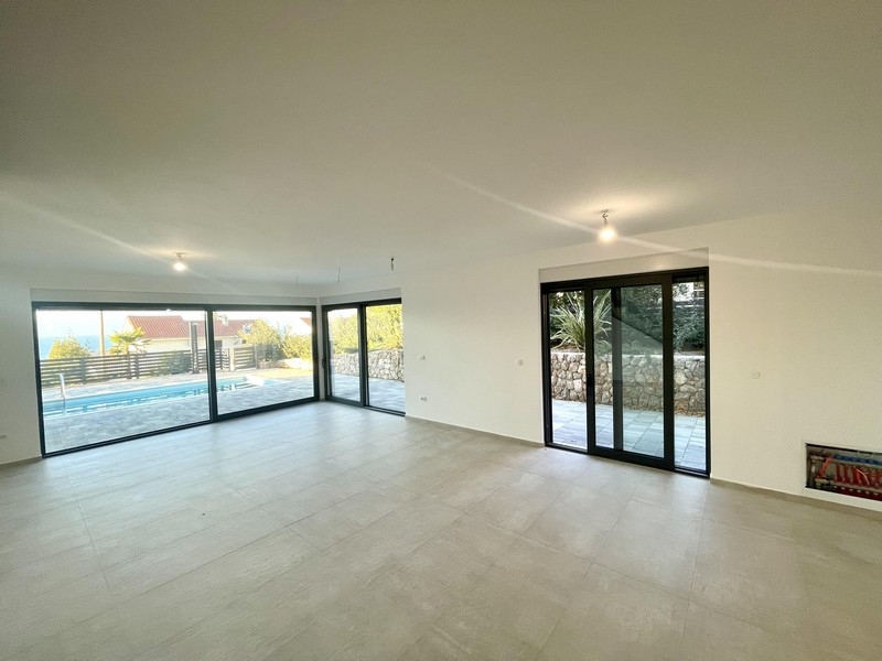 Jasny salon ze szklanym frontem i widokiem na basen