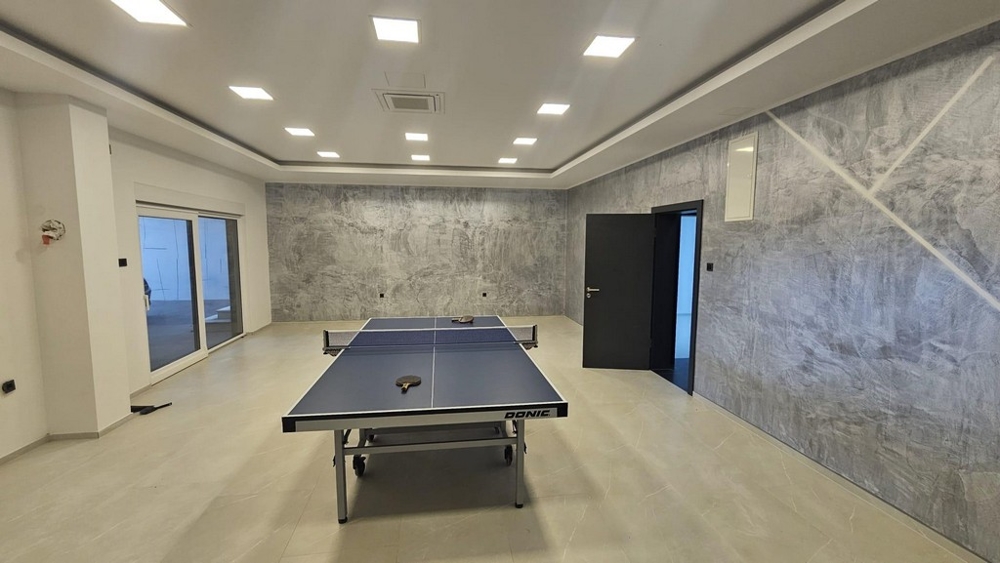 Przestronna sala rekreacyjna lub fitness ze stołem do tenisa stołowego