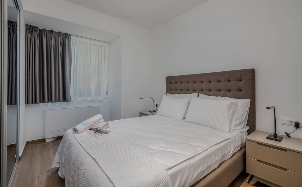 Przytulna sypialnia z oknem i zasłonami zaciemniającymi