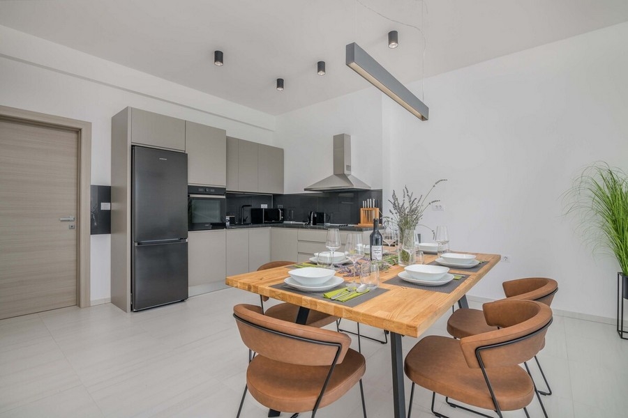 Jadalnia z designerskim stołem i nowoczesną kuchnią