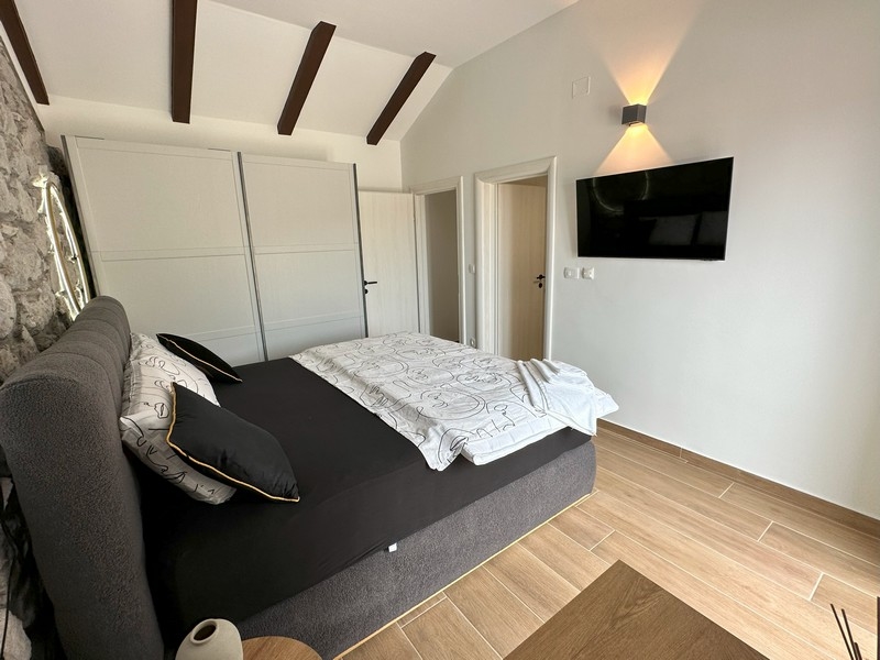 Sypialnia z TV i drewnianym sufitem