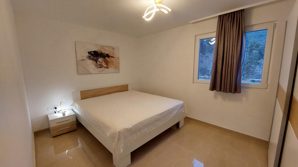 Sypialnia z podwójnym łóżkiem i neutralnymi meblami