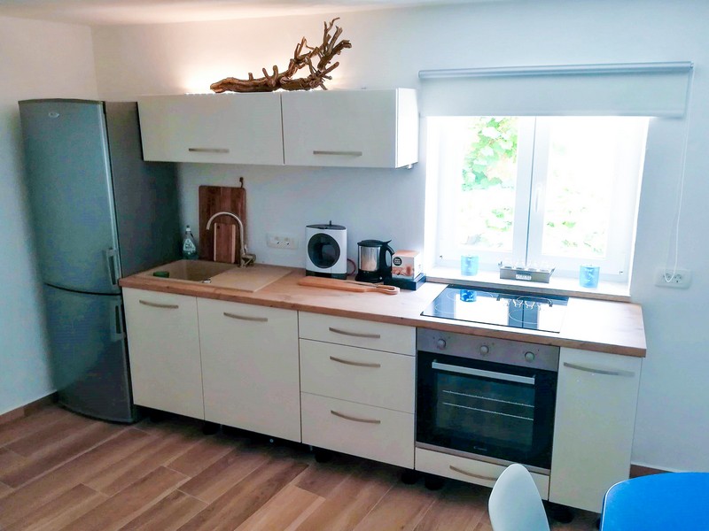 Jasna kuchnia z drewnianymi blatami i nowoczesnym wyposażeniem