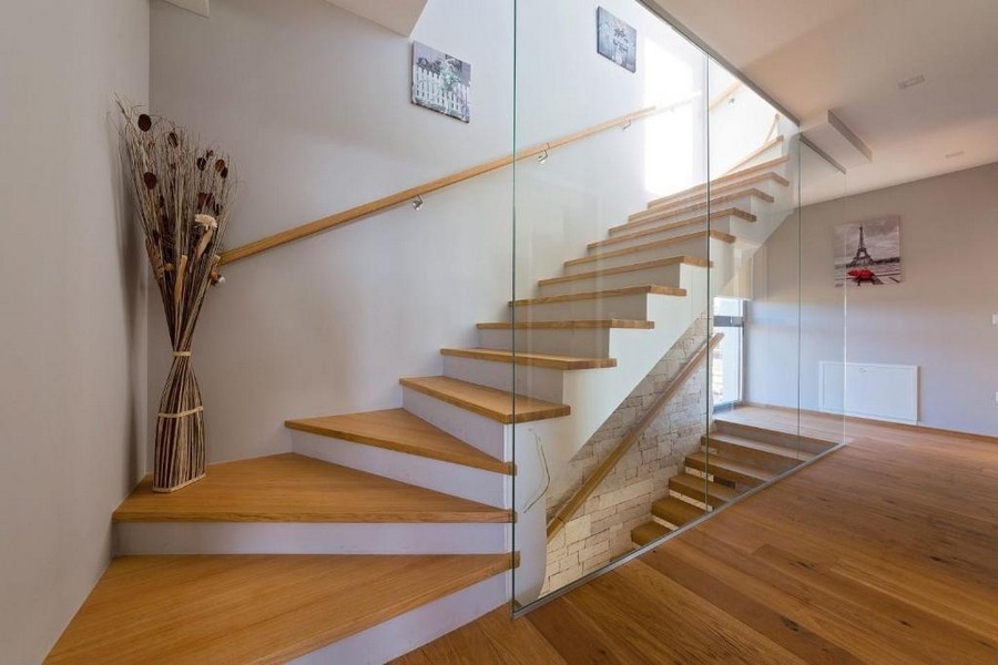 Schody ze szklanymi balustradami i drewnianymi stopniami