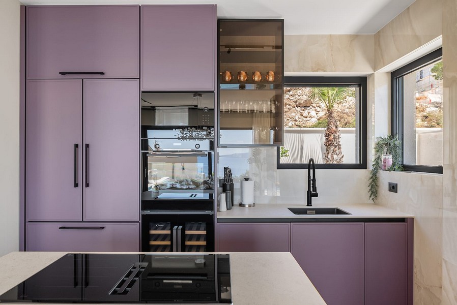 Nowoczesna kuchnia z fioletową armaturą.