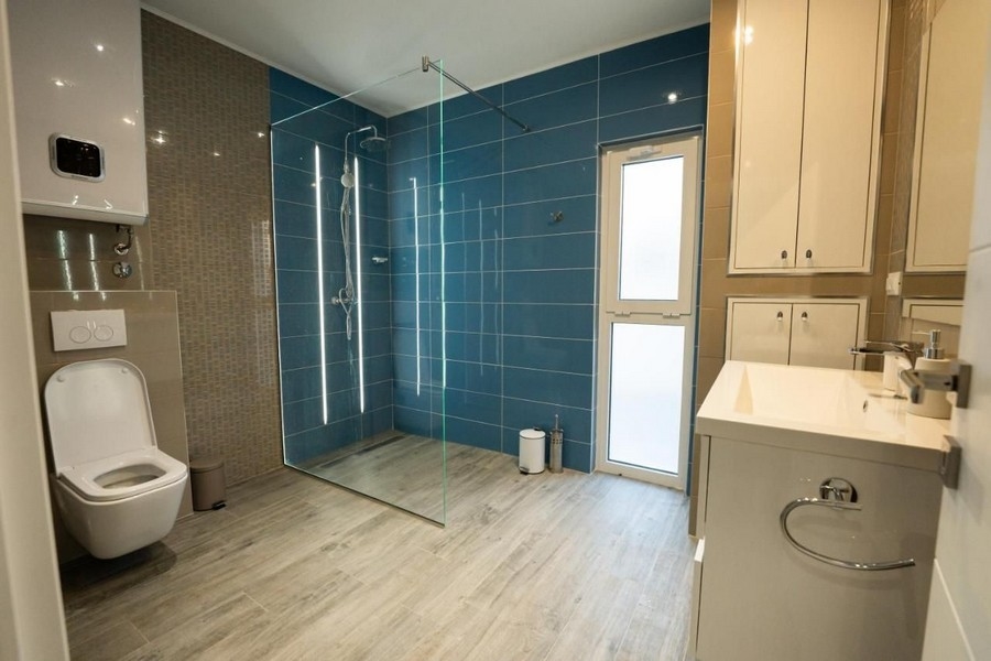 Duża łazienka z kabiną prysznicową i niebieskimi kafelkami