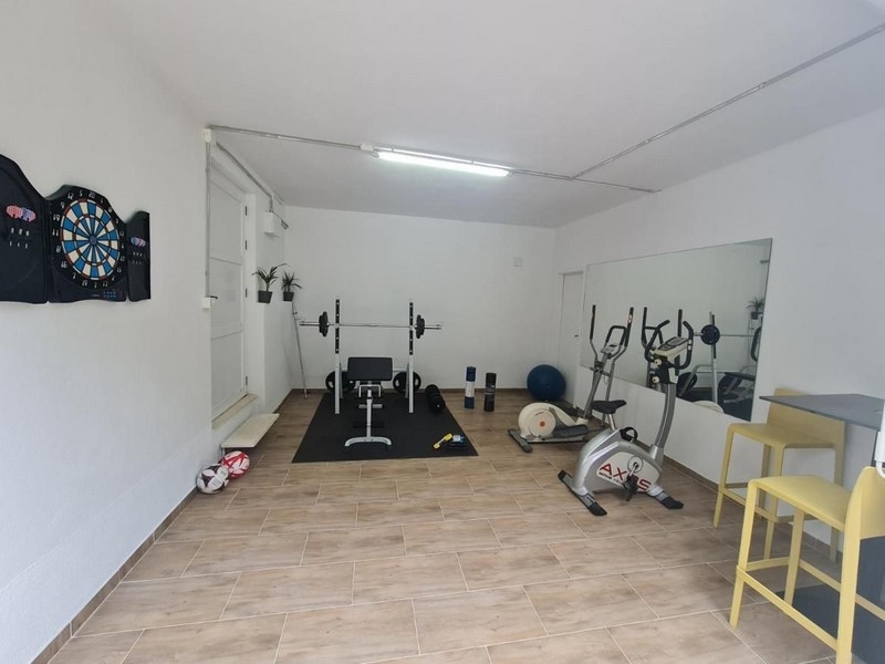 Sala fitness ze sprzętem sportowym i tarczą do gry w rzutki