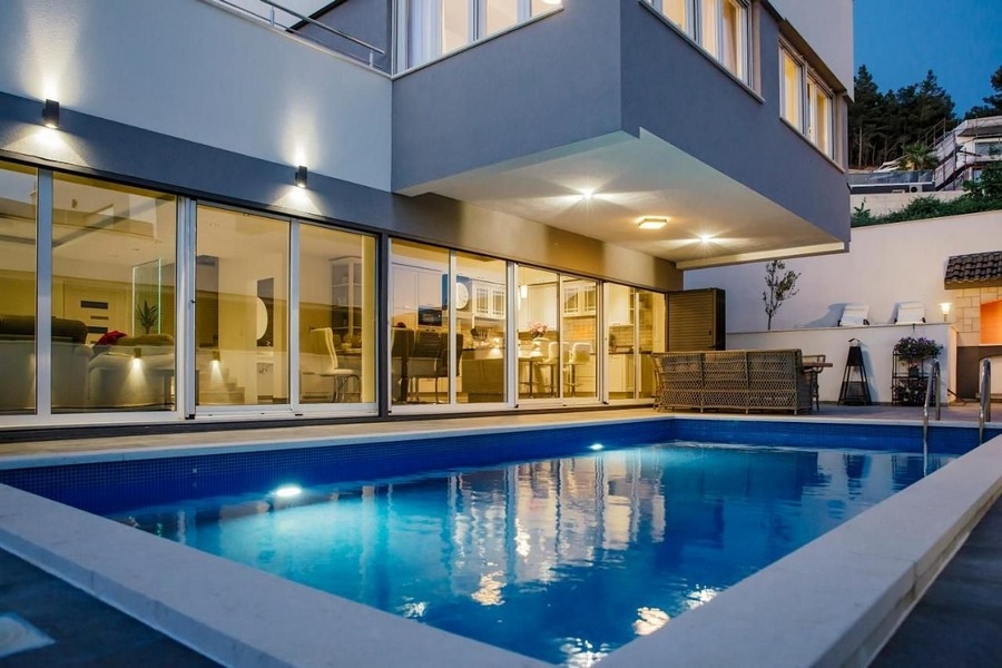 Widok zewnętrzny willi z basenem o zmierzchu