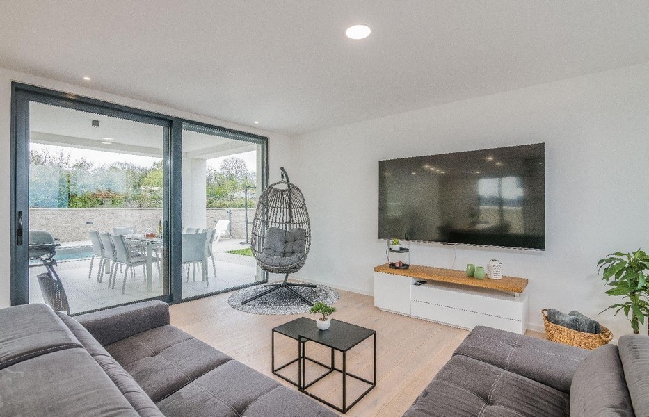 Nowoczesny salon z dużym przeszklonym frontem i telewizorem