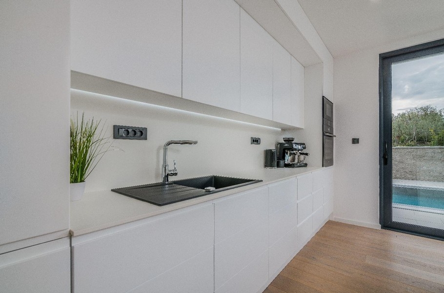 Aneks kuchenny ze zlewem, ekspresem do kawy i widokiem na zewnątrz