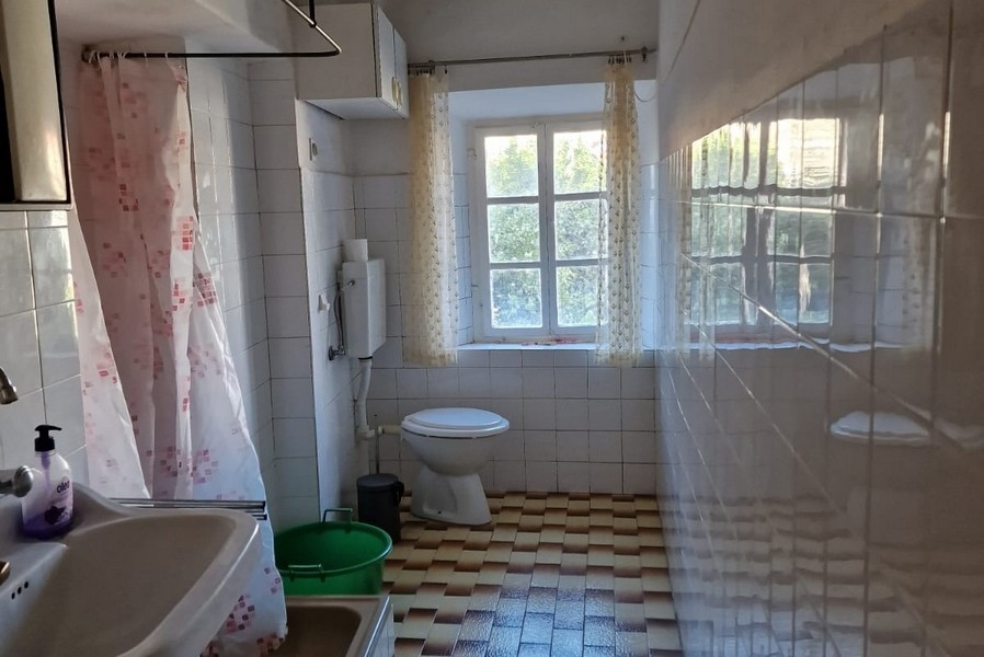 Łazienka z oknem, prysznicem, umywalką i toaletą