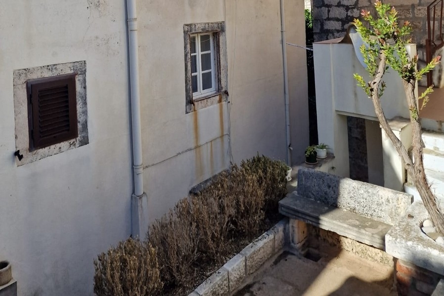 Wewnętrzny dziedziniec z kamiennymi ścianami i małą ławką