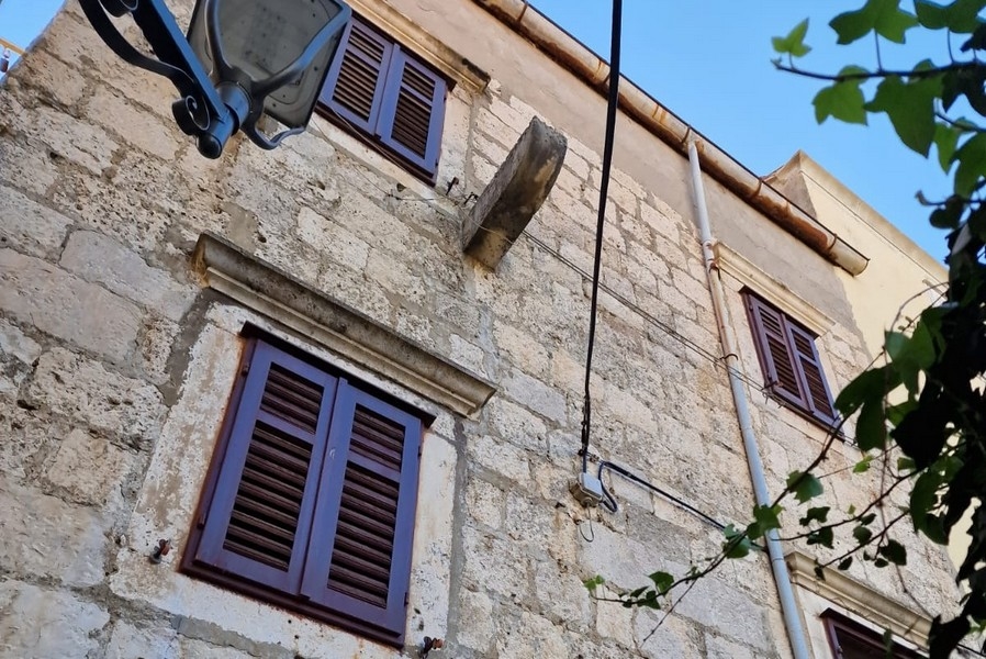 Fasada kamiennego domu z okiennicami i ścianami z kamienia naturalnego