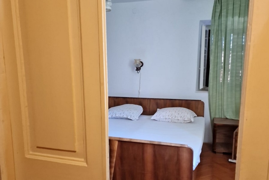 Widok przez drzwi do sypialni z podwójnym łóżkiem