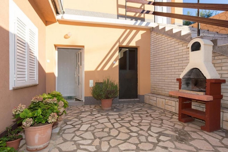 Wewnętrzny dziedziniec z miejscem do grillowania i schodami zewnętrznymi