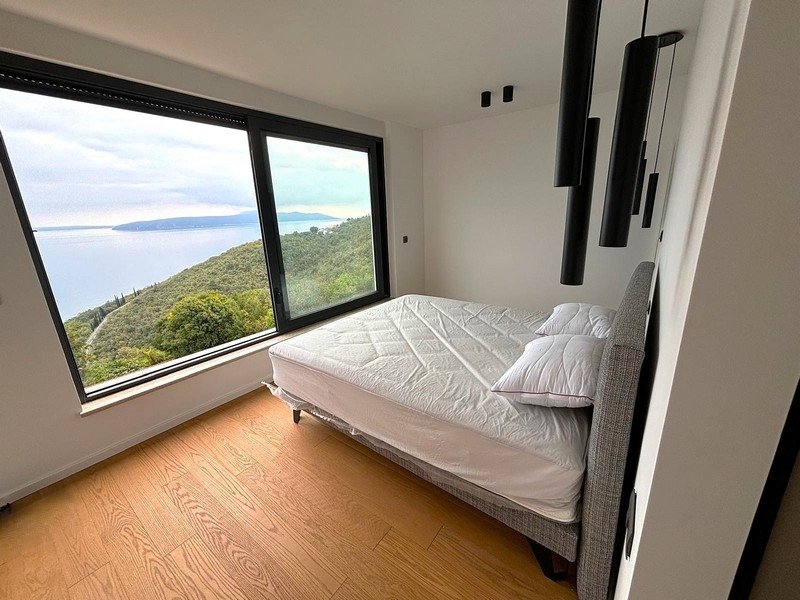 Jasna sypialnia z dużym oknem i widokiem na morze