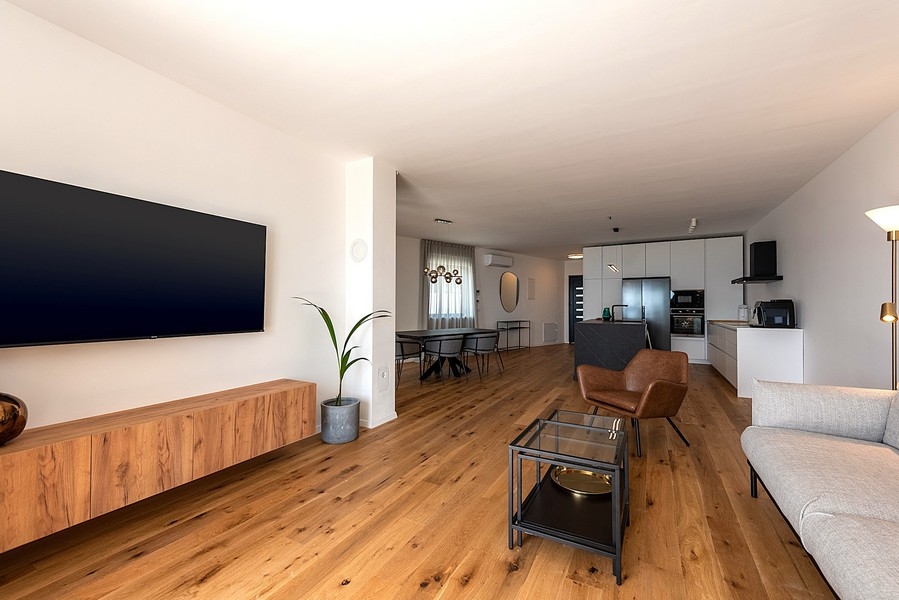 Otwarta część dzienna z kuchnią, jadalnią i jasnymi meblami