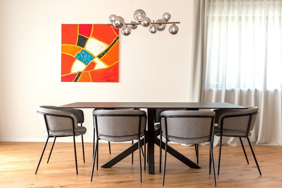 Jadalnia z designerską lampą i dużą grafiką na ścianie