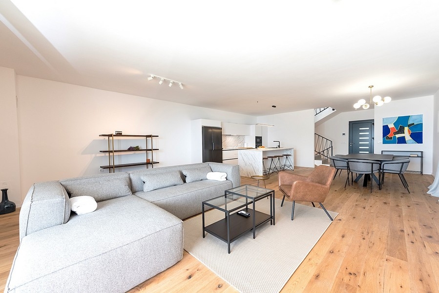 Przestronny salon z sofą, jadalnią i schodami na piętro