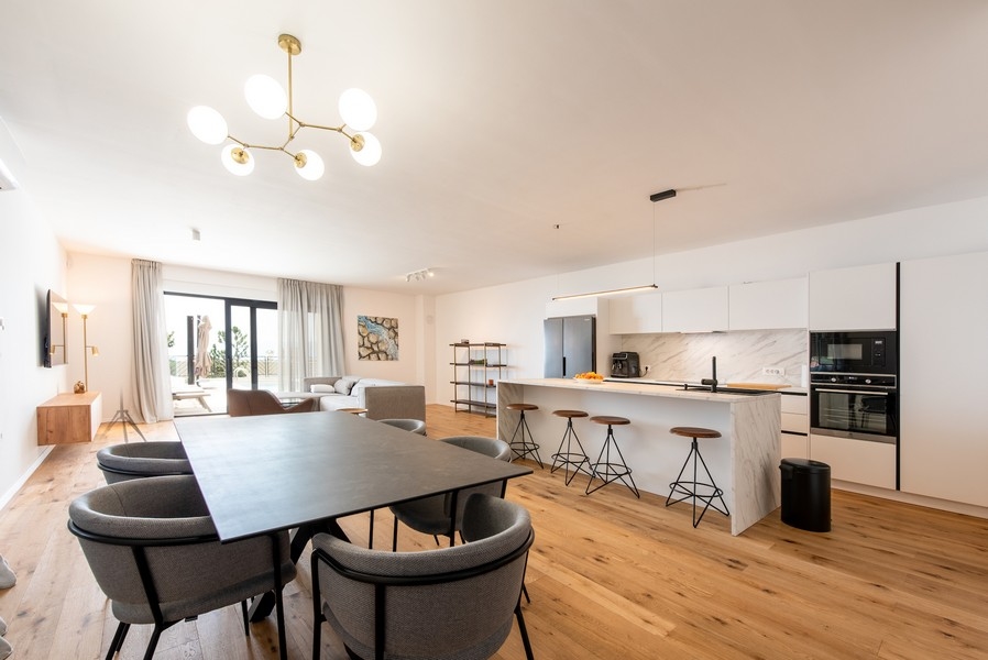 Otwarta część dzienna z kuchnią, jadalnią i nowoczesnym umeblowaniem