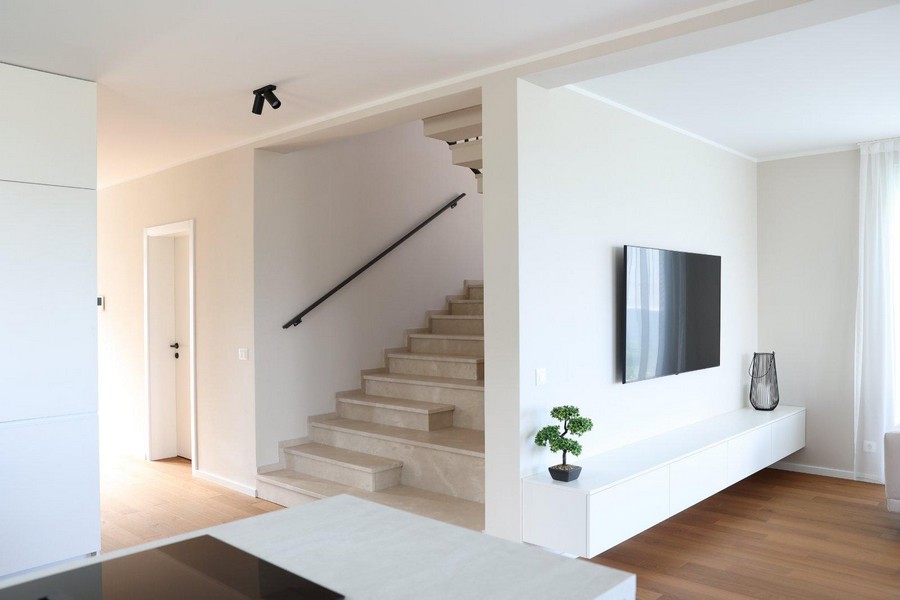 Nowoczesna, jasna kuchnia z wiszącymi półkami i sprzętem do zabudowy