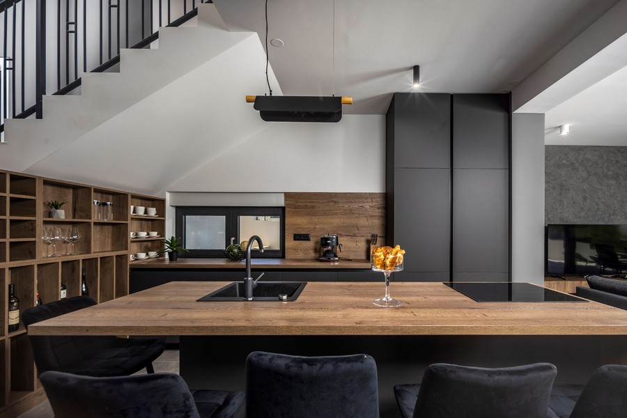 Nowoczesna kuchnia z drewnianym blatem i czarnymi elementami