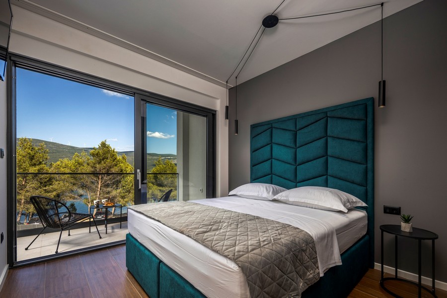 Sypialnia z dużym łóżkiem i panoramicznym oknem