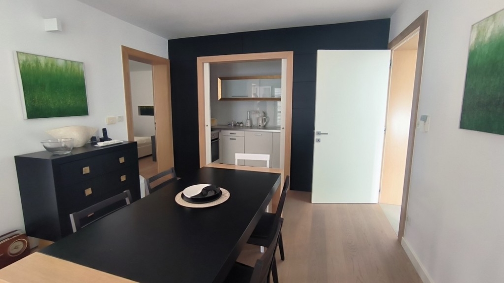 Jadalnia z ciemnym stołem i połączeniem z kuchnią