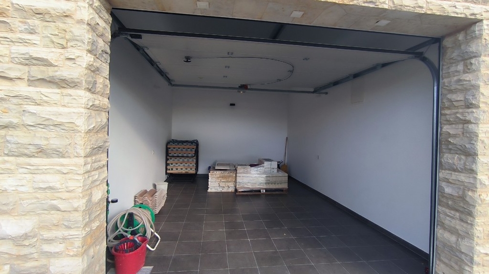 Garaż wyłożony kamieniem i podłogą wyłożoną kafelkami