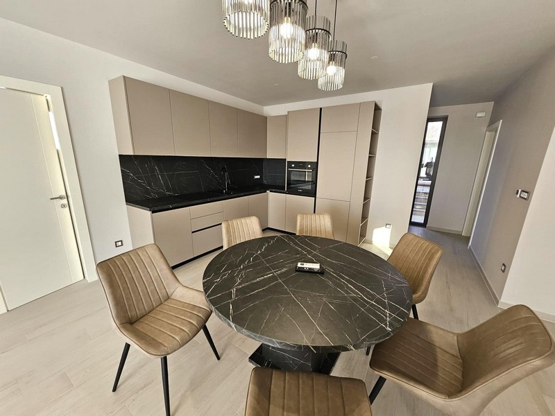 Nowoczesna kuchnia z czarnymi blatami i okrągłym stołem jadalnym