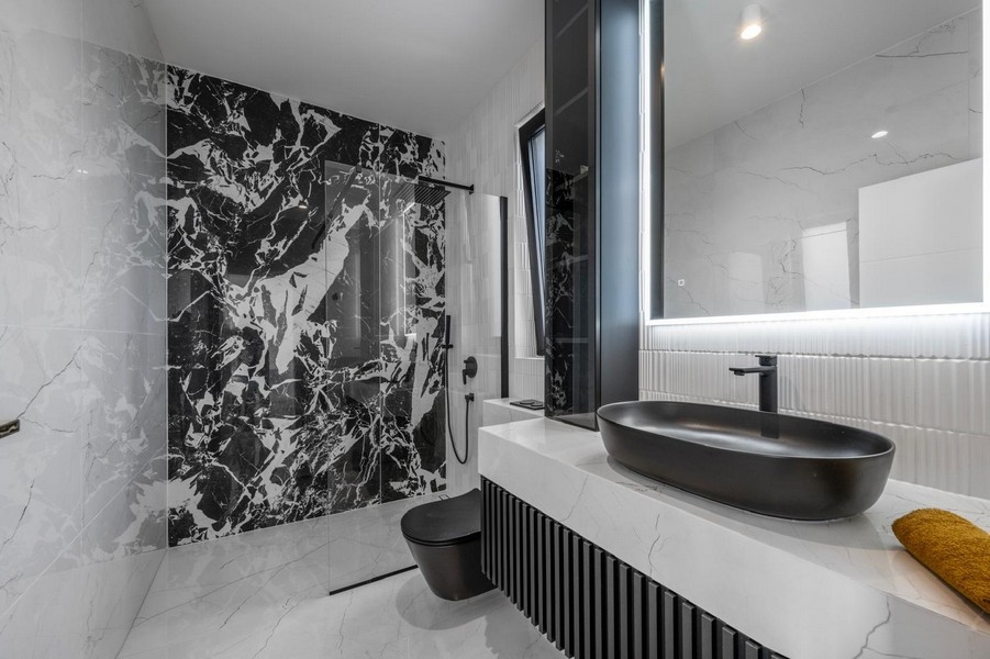 Stylowa łazienka z marmurowymi płytkami i czarnymi meblami