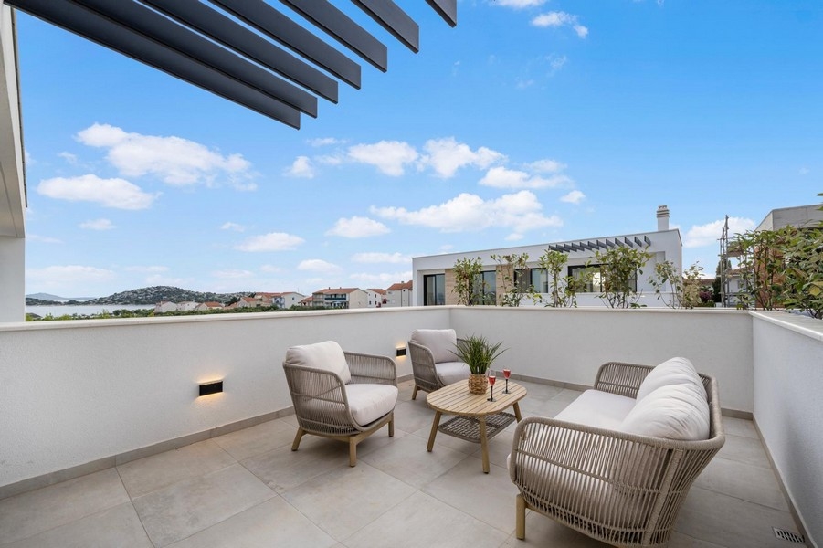 Nowoczesny taras z miejscami do siedzenia i widokiem na morze w Tribunj