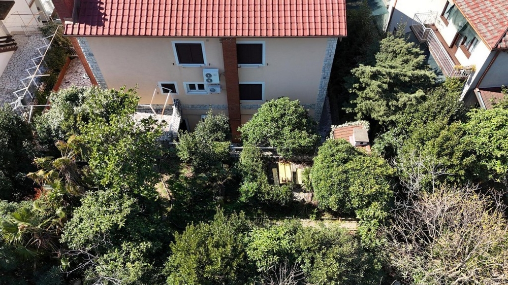 Widok z tyłu domu z zielonym ogrodem i częścią wypoczynkową