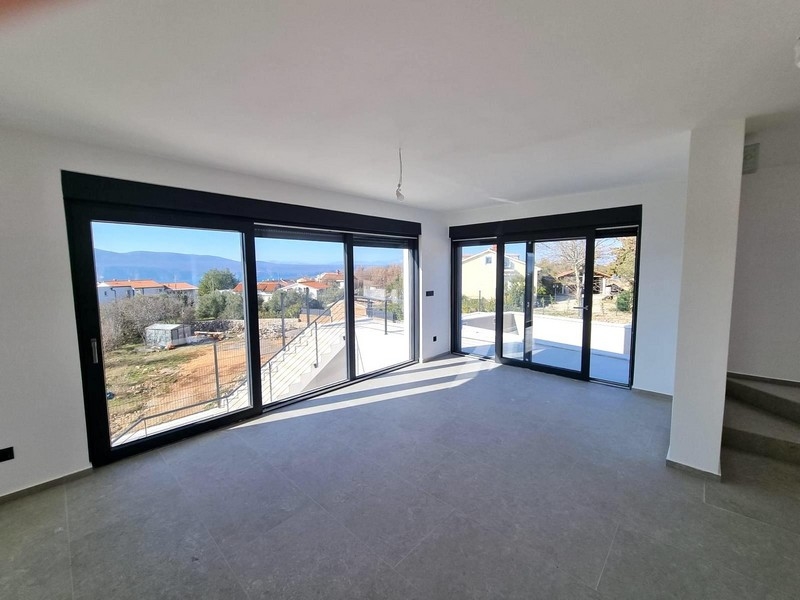 Część dzienna z dużymi szklanymi frontami i widokiem na morze