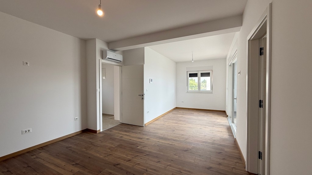 Jasny salon z parkietem i dużymi oknami