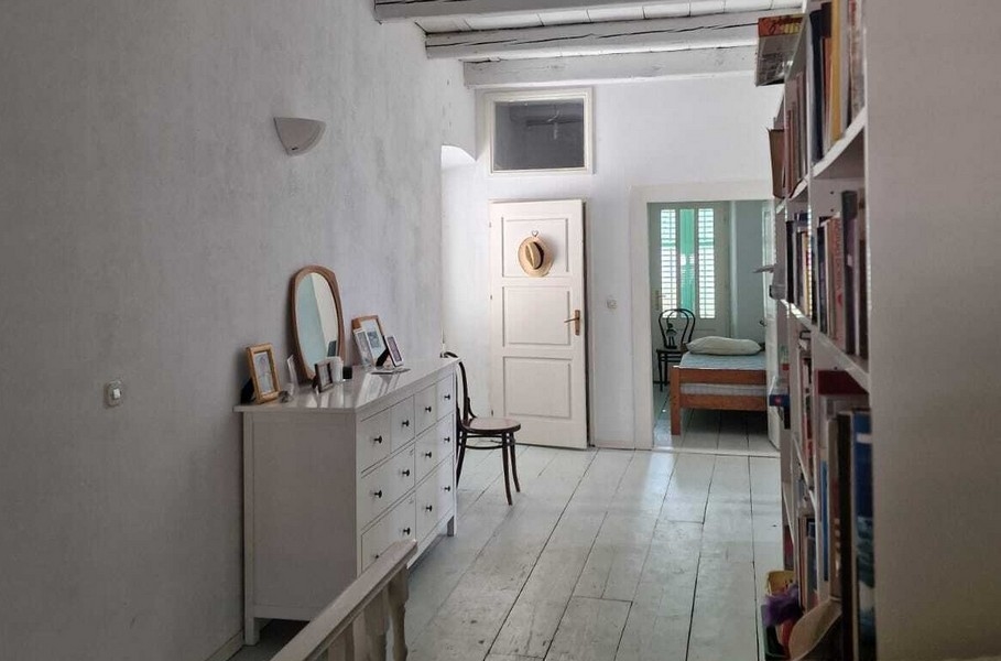 Przedpokój z półką na książki i przejściem do sypialni