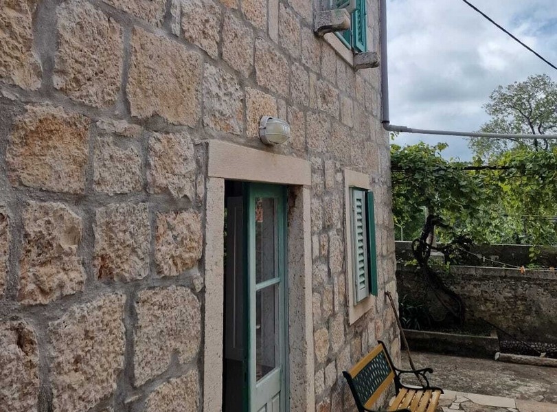 Kamienna fasada z wejściem i okiennicami