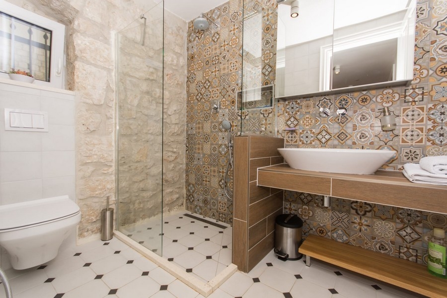 Łazienka z prysznicem, bidetem i wzorzystymi płytkami ściennymi