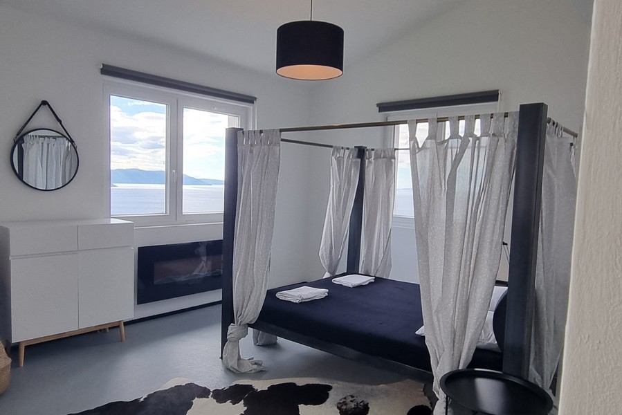 Sypialnia z łóżkiem z baldachimem i widokiem na morze